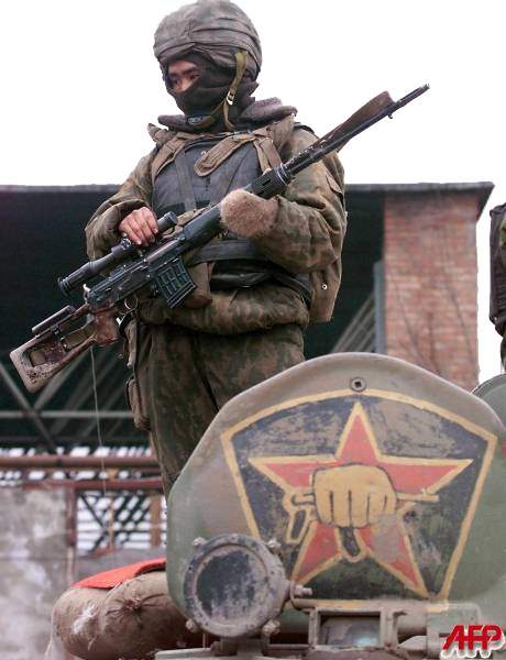 Operador do Spetsnaz na Chechnia. Observe o antigo simbolo da unidade na escotilha do blindado.