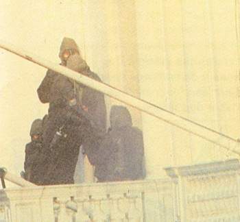 Operadores do SAS entram pela frente da embaixada, diante das câmeras de TV.